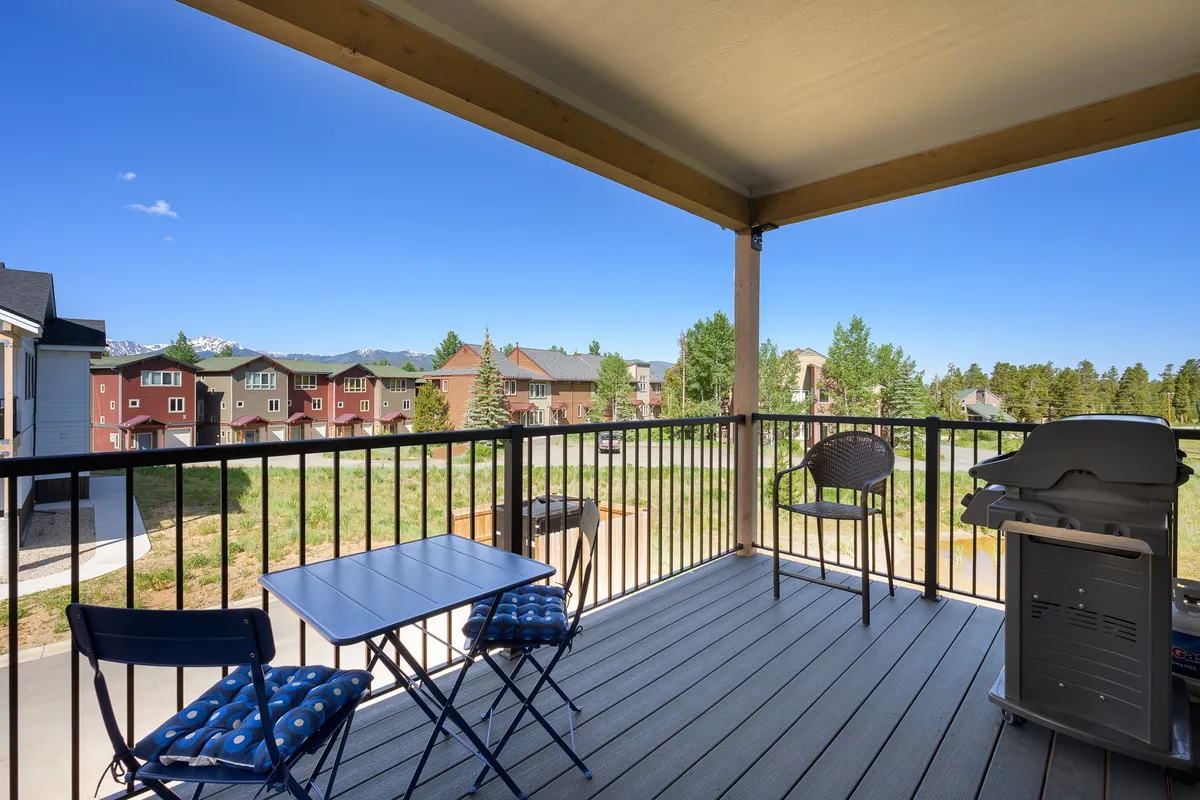 An inviting outdoor seating area with a barbecue grill, situated to capture a beautiful view of the neighborhood and distant mountains. The space is ideal for morning coffee, evening barbecues, or simply relaxing with a book while enjoying the fresh mountain air.