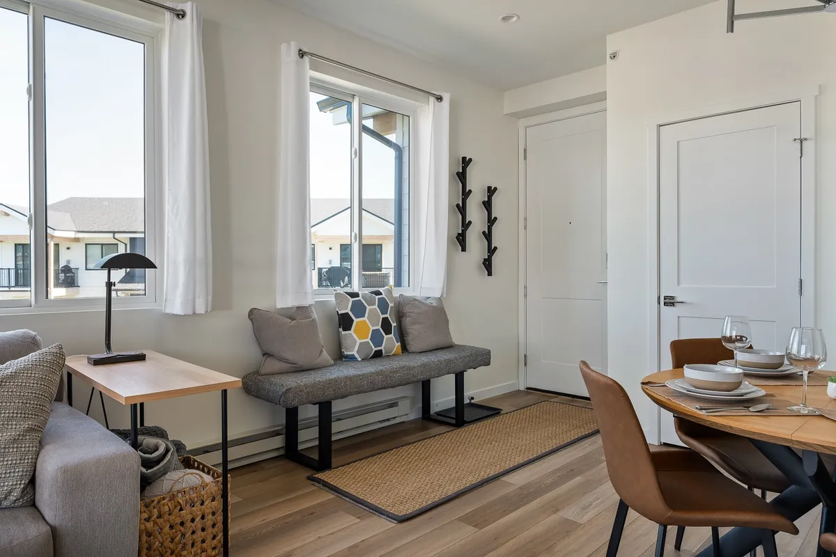A welcoming seating area complete with cushioned seats and a table set for dining. The scene is oriented towards the entrance door, hinting at guest arrival and effortless entry.